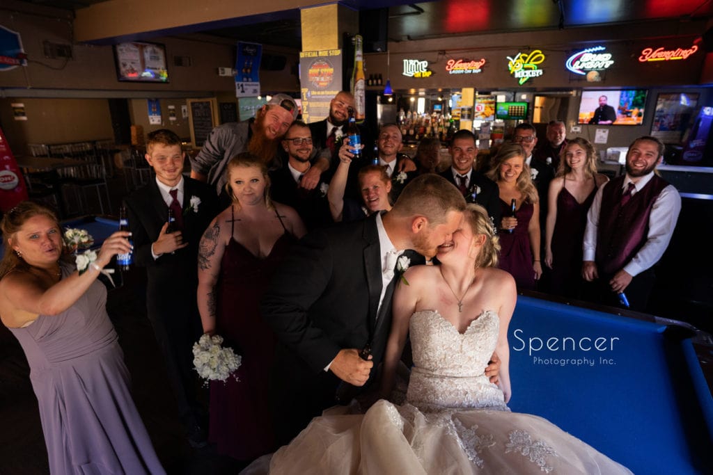 bride and groom kissing in pub on wedding day
