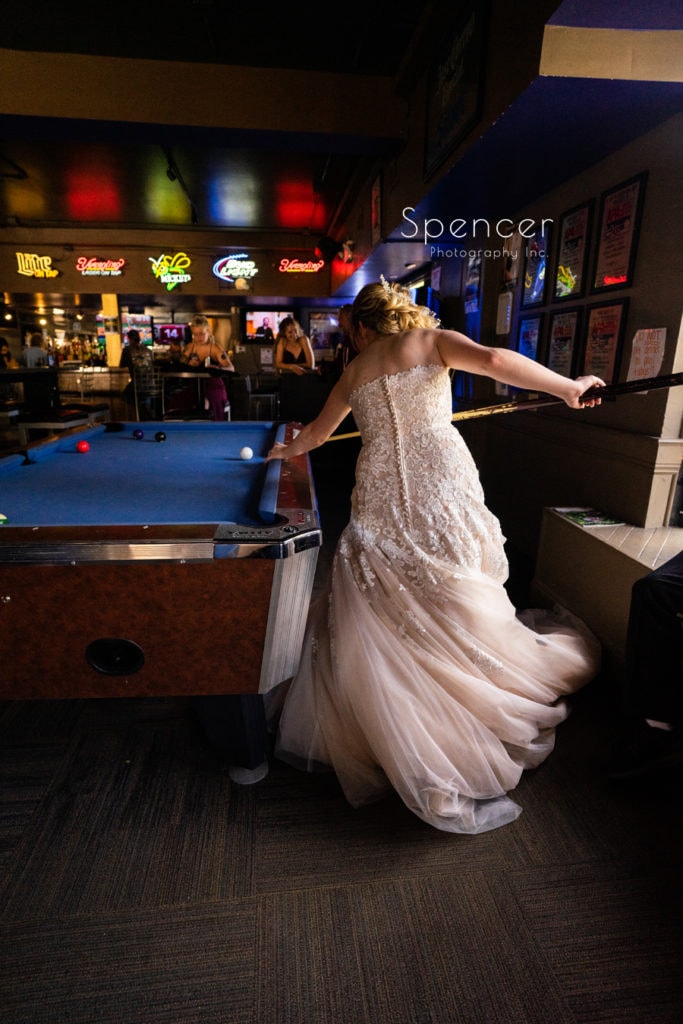 bride playing pool on her wedding day
