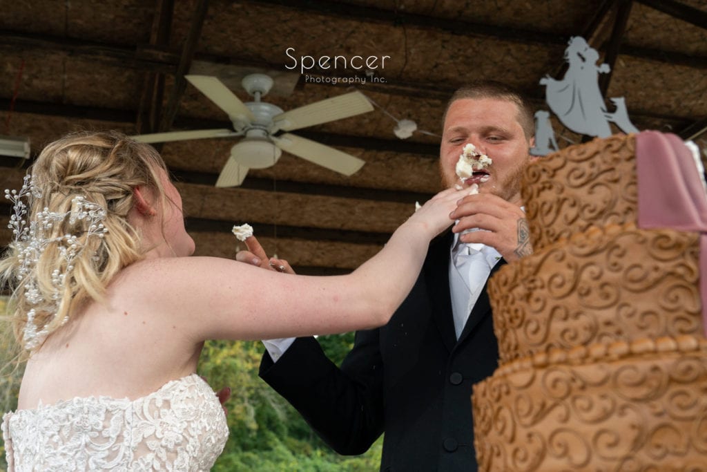 bride smashing wedding cake in grooms face