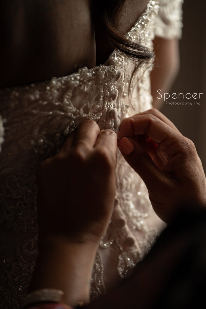  wedding dress getting buttoned at Glenmoor Country Club