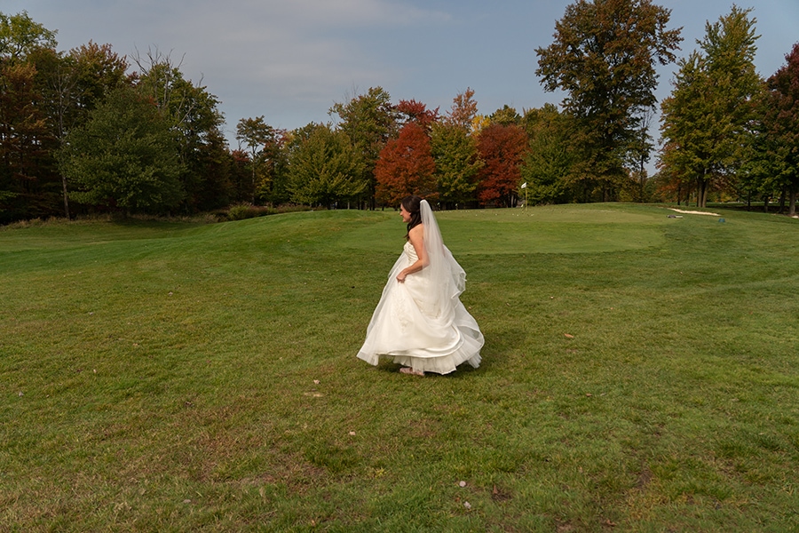  bride walking in field to meet groom before wedding at Stonewater Cleveland