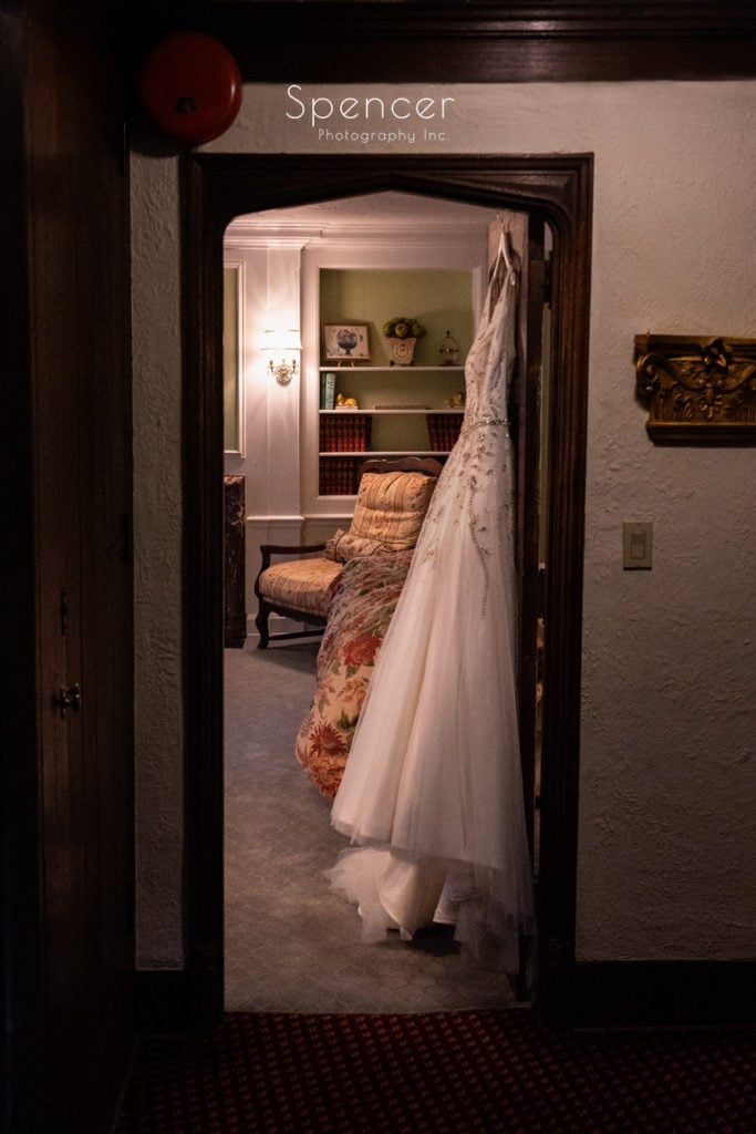 wedding dress hanging on door at The Club at Hillbrook