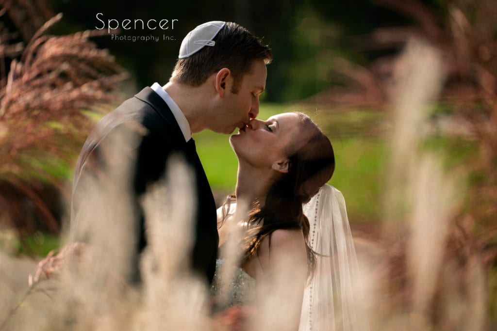  bride and groom kissing at wedding ceremony at Stonewater