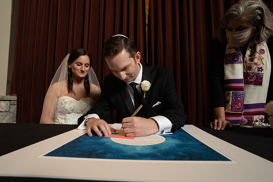 groom signing ketubah at Jewish wedding at Stonewater Cleveland