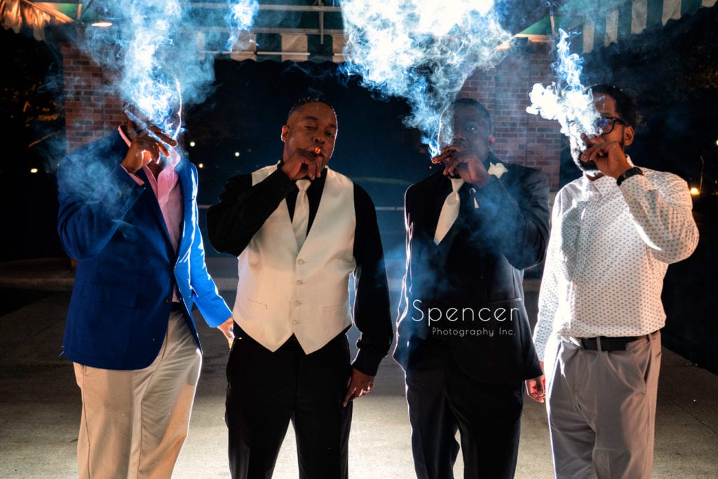 groom smoking cigar at wedding reception at Glenmoor