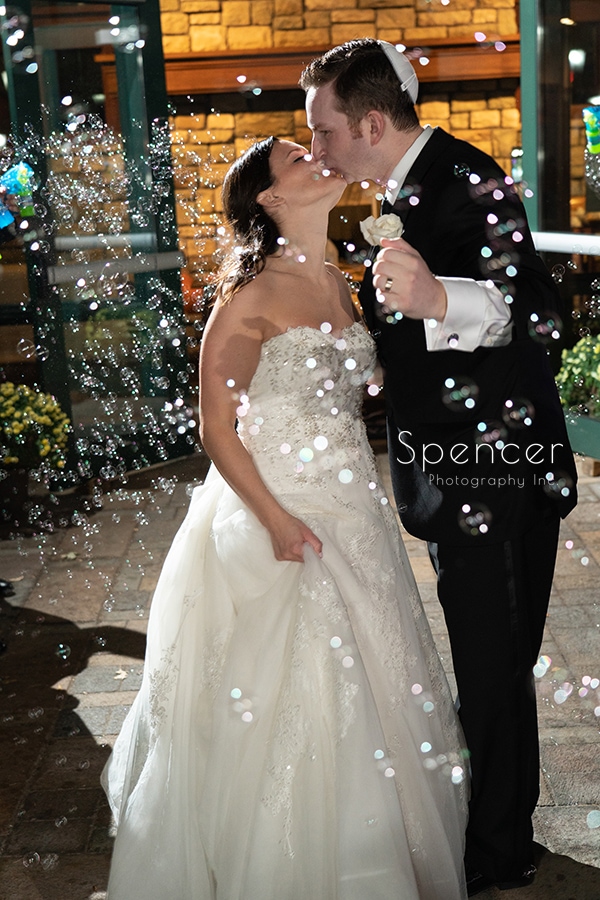 bride and groom exiting their wedding reception thru bubbles