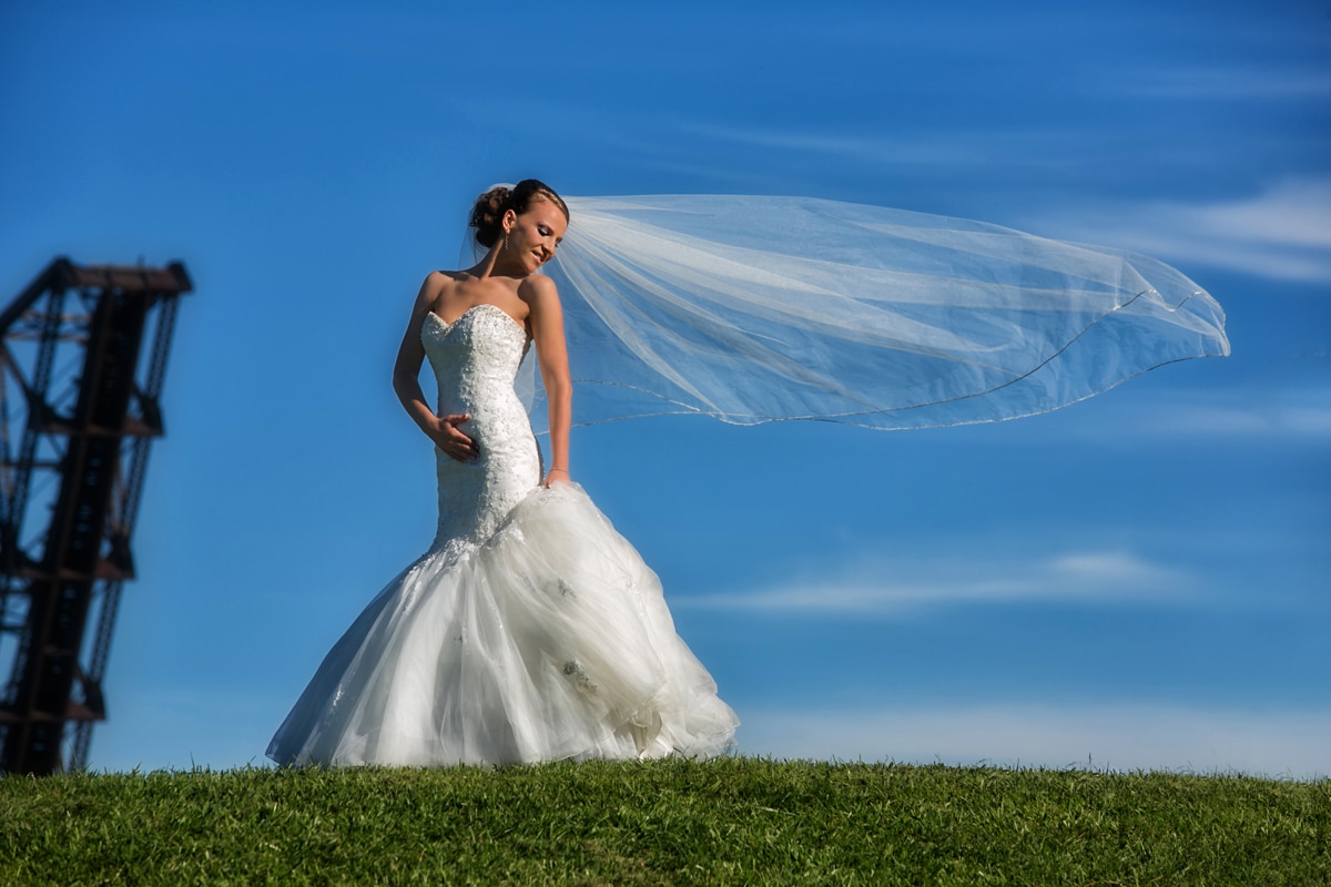 bride holding blowing veil in Cleveland flats