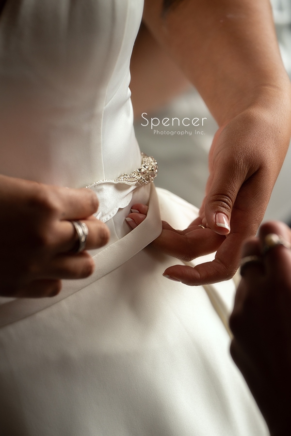 bride adjusting belt on wedding dress