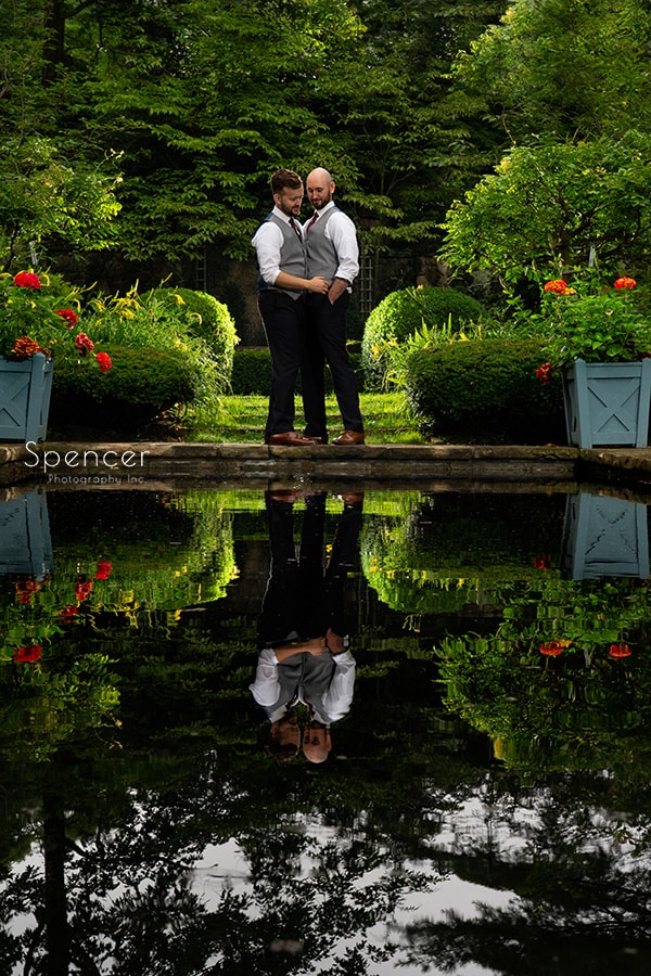 grooms posing in English Garden after gay wedding at Stan Hywet