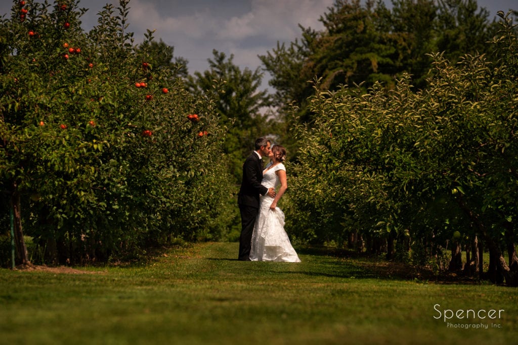 bride and groom kissing in apple orchard at Patterson Fruit Farm