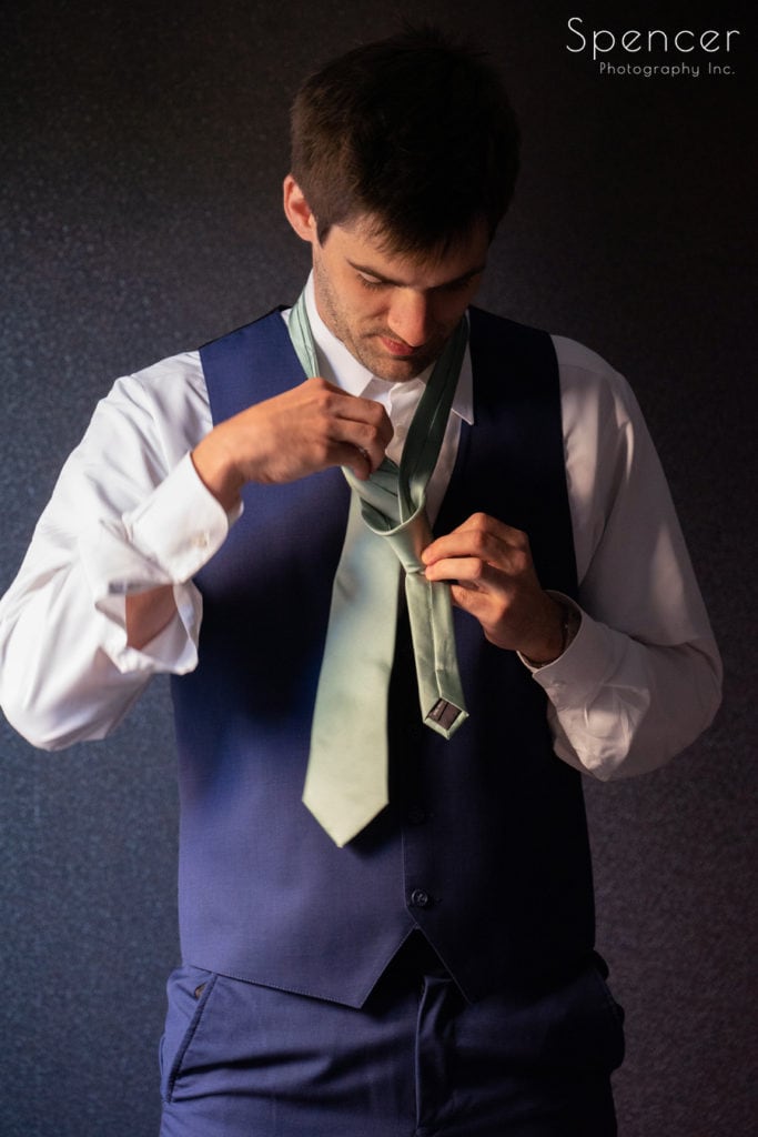  groom putting on his tie