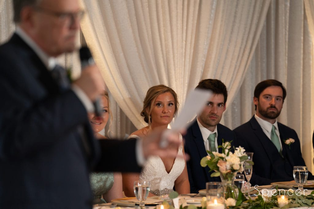bride watching father give reception speech at Firestone