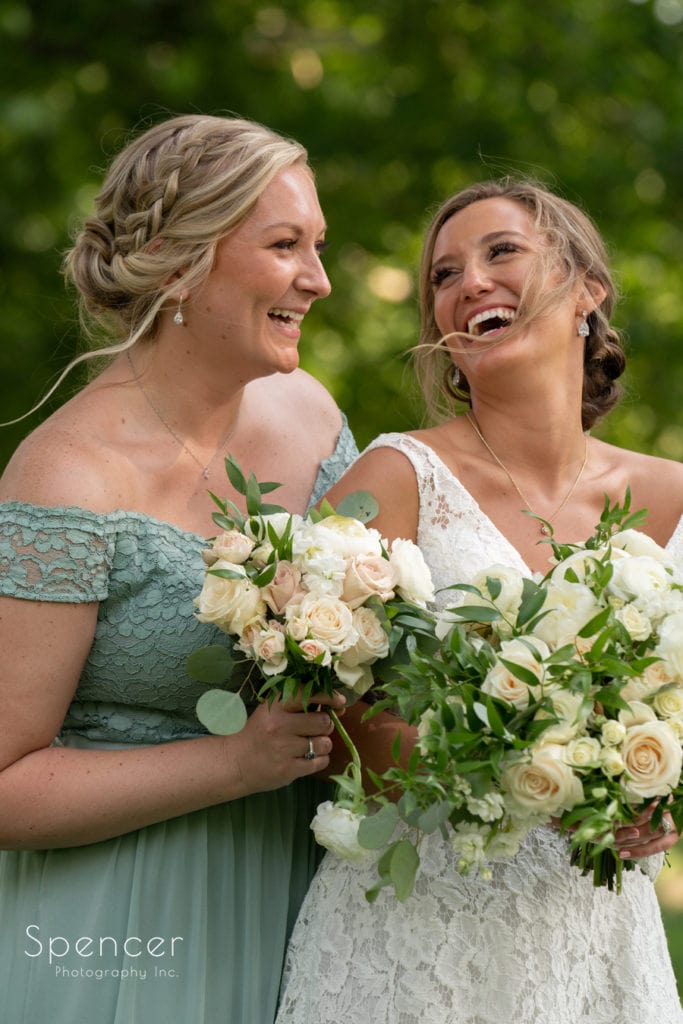 bride laughing with maid of honor at Firestone Country Club