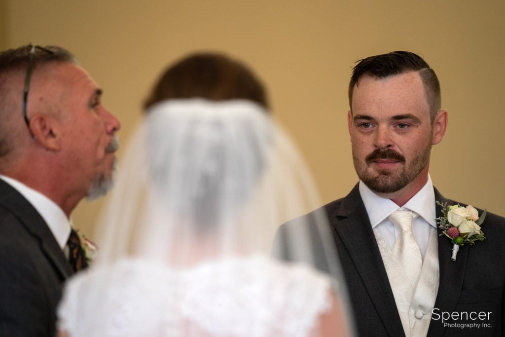 groom looking at bride during wedding ceremony