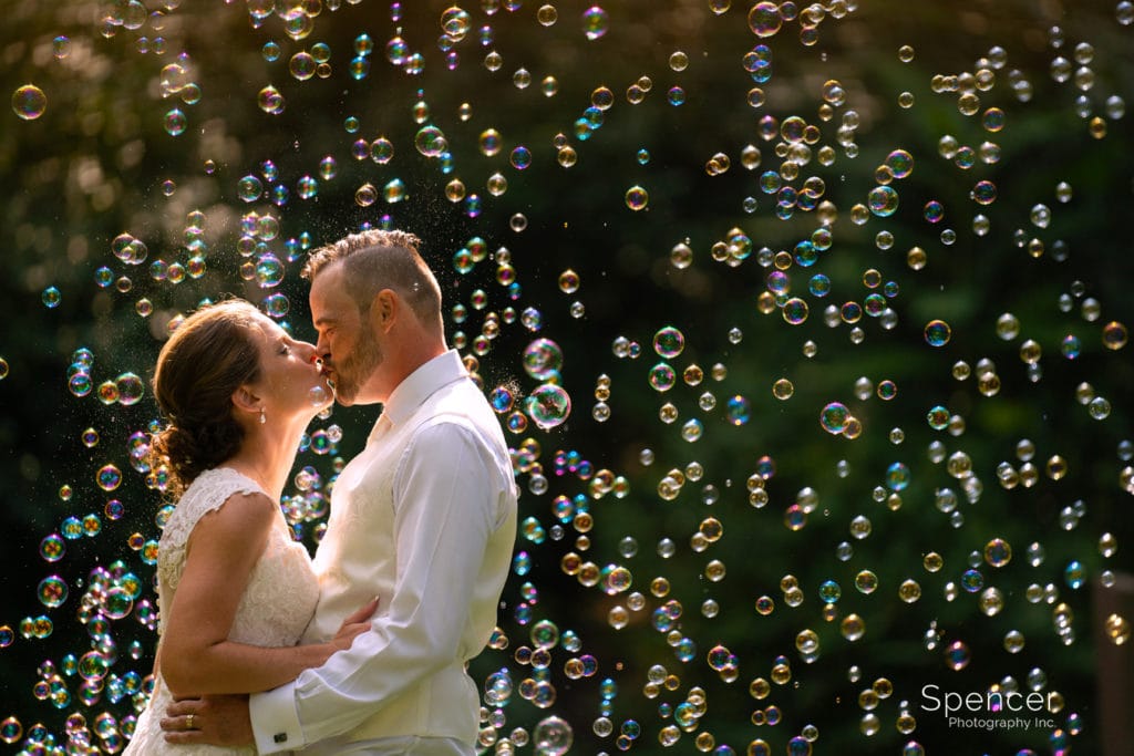 couple kissing in wedding picture with bubbles