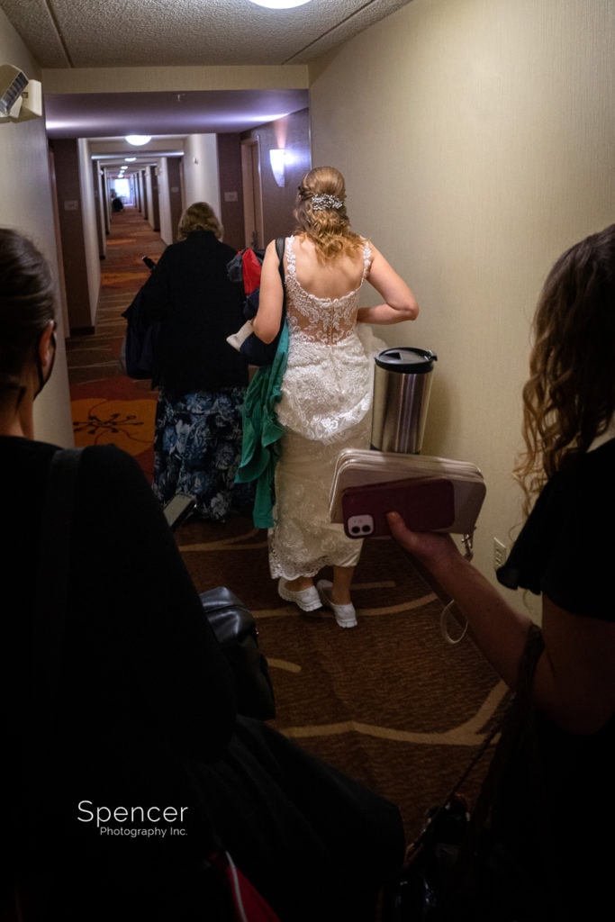 bride walking thru hotel to wedding ceremony