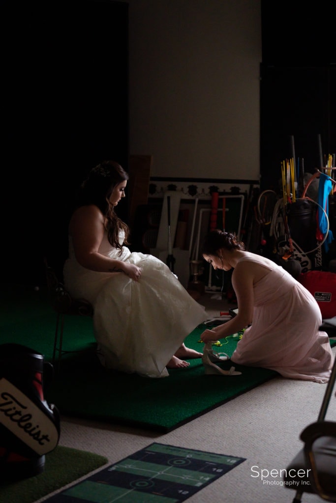 maid of honor helping bride with shoes