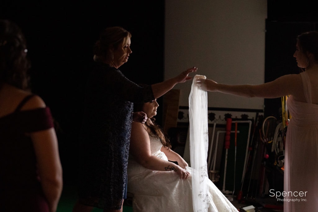 mom helping bride with veil