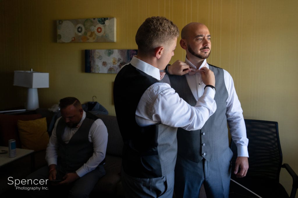 groomsmen helping groom