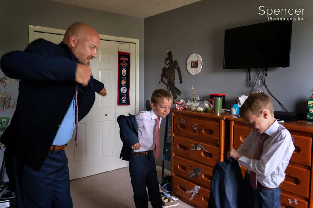 groom putting on jacket with his sons