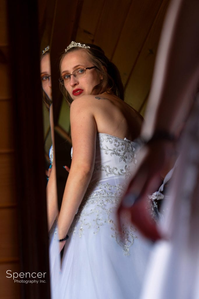 bride looking at dress in mirror