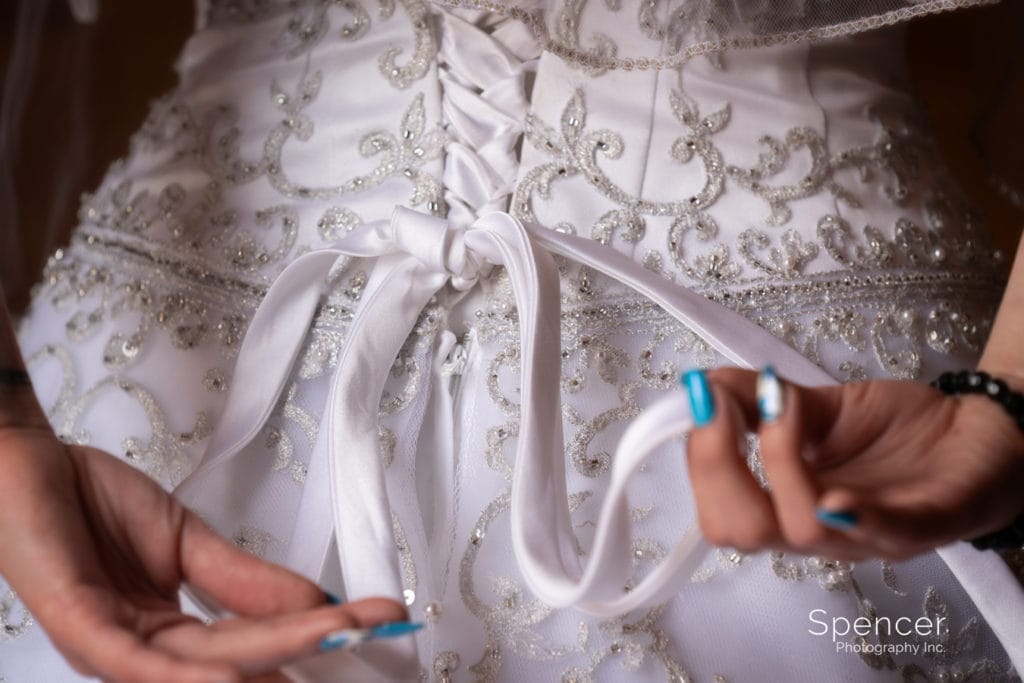 bride adjusting bow on her wedding dress
