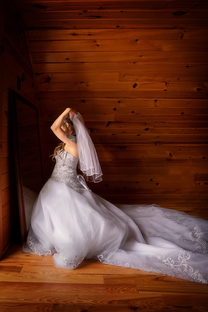 bride adjusting her veil in a mirror