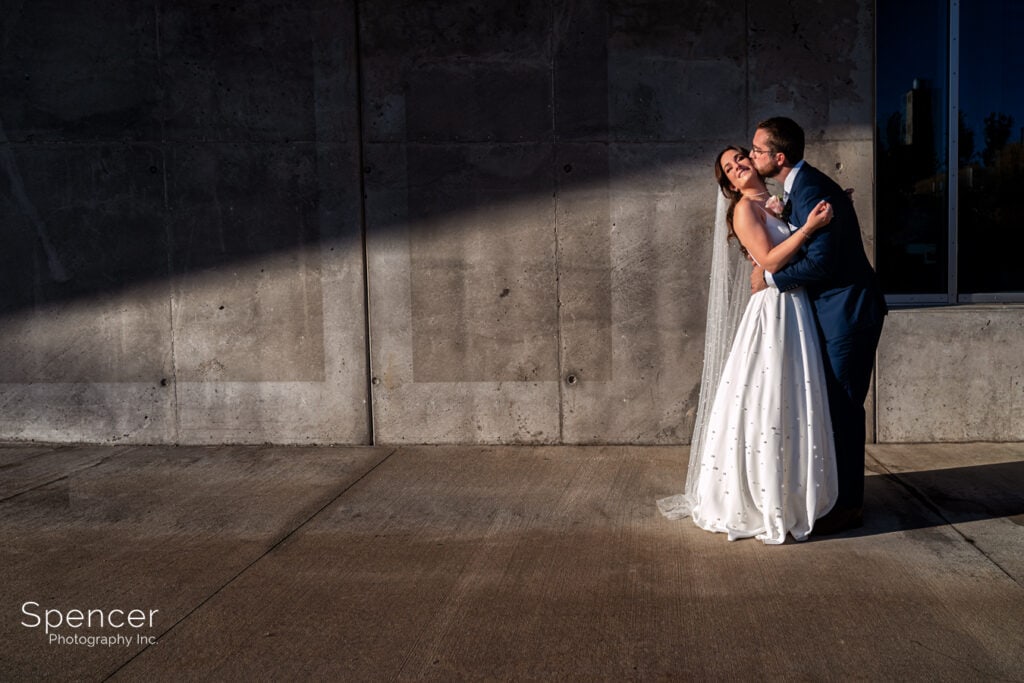 groom kissing bride outside of Akron Art Museum