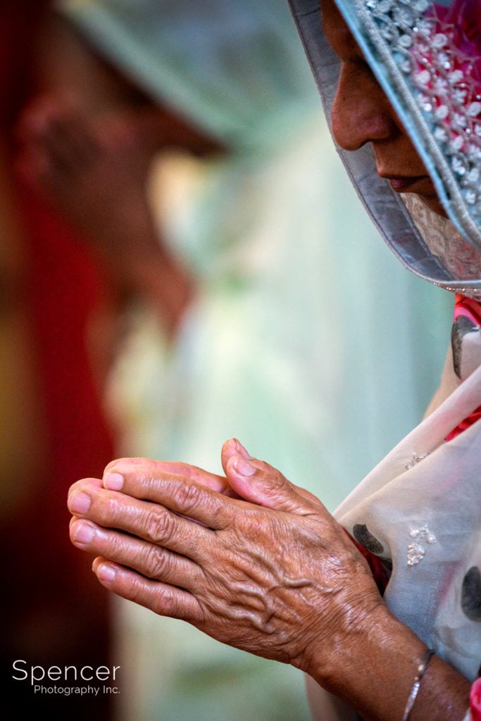 elderly woman praying at Sikh wedding