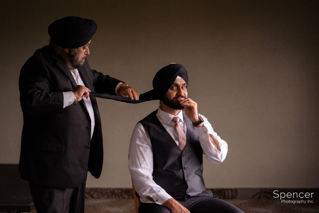 Sikh father helping groom with turban