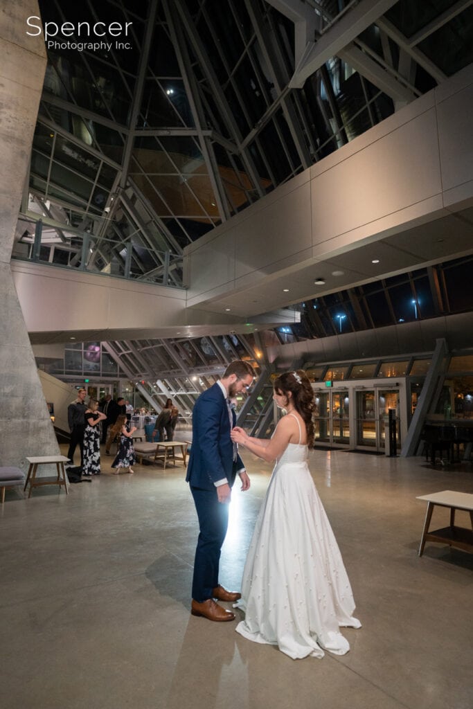 bride buttoning grooms jacket at Akron Art Museum