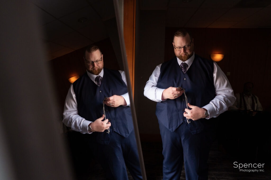 groom putting on pocket watch at Akron Hilton
