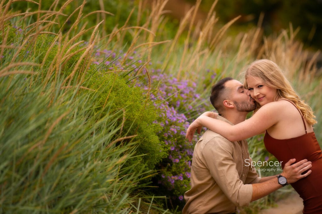 man kissing woman in engagement picture at Cleveland Botanical Garden