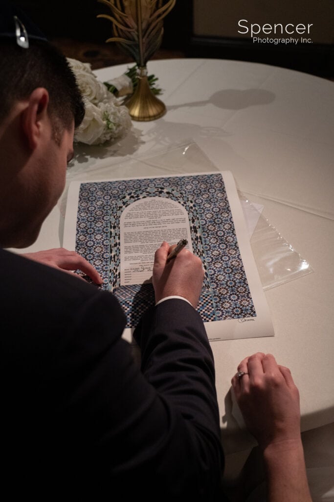 groom signing his ketubah