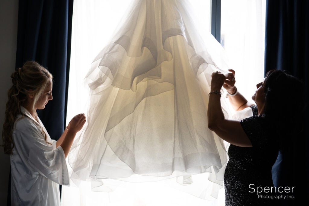 mom helping bride with wedding dress in Kent Hotel