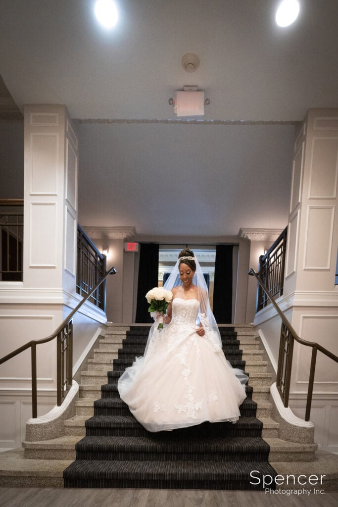 bride walking down staircase to wedding ceremony