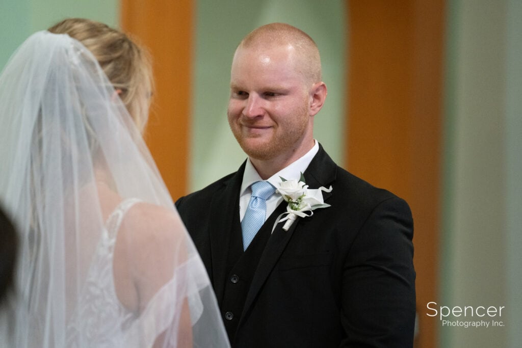 groom smiling at bride during ceremony