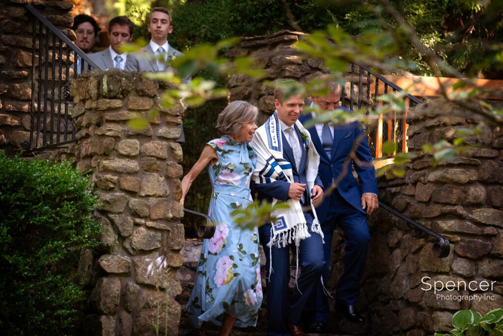 groom walking with parents to wedding at Landolls