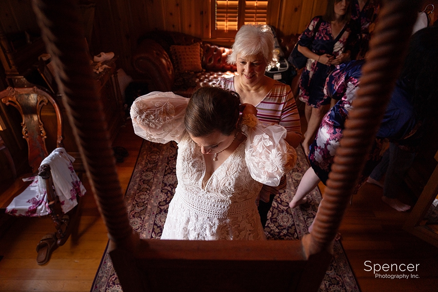 bride putting on wedding necklace at Vrooman Mansion