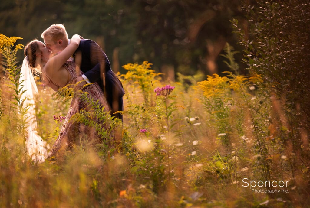 groom kissing bride in Pennsylvania field