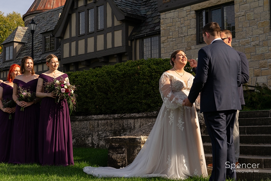 bride smiling at groom during wedding ceremony at Ewing Manor