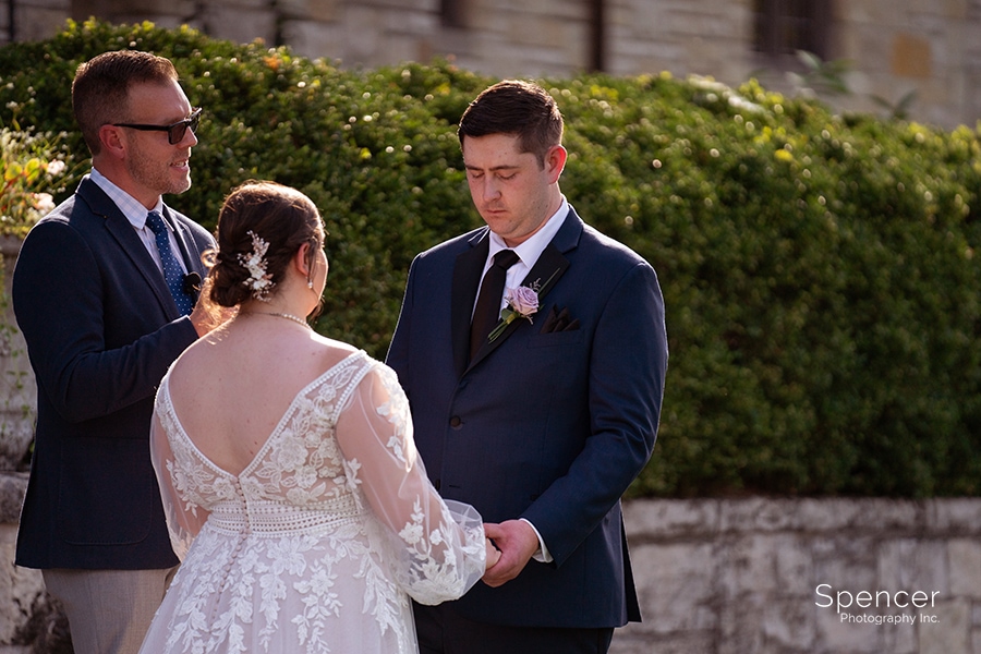 groom looking at bride during wedding ceremony at Ewing Manor