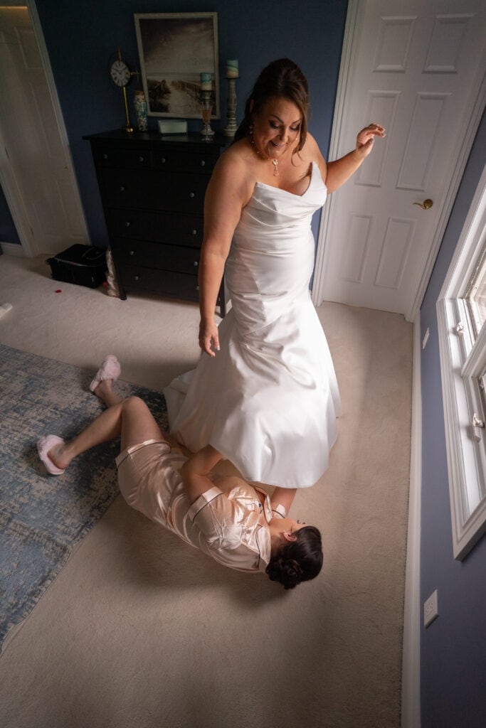 bridesmaid helping bride with shoe
