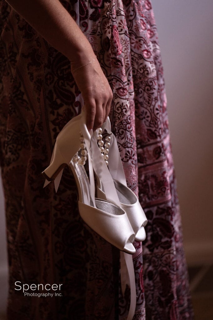 bride holding her wedding shoes