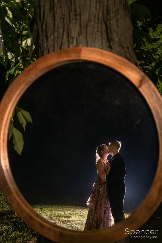 artistic wedding picture of bride and groom kissing in mirror