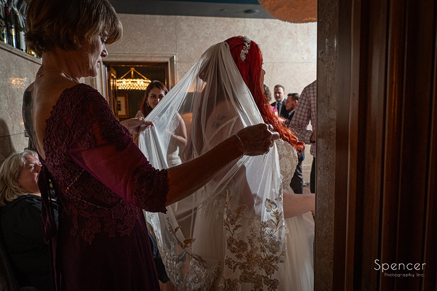 mom helping bride with veil before wedding at Marble Room