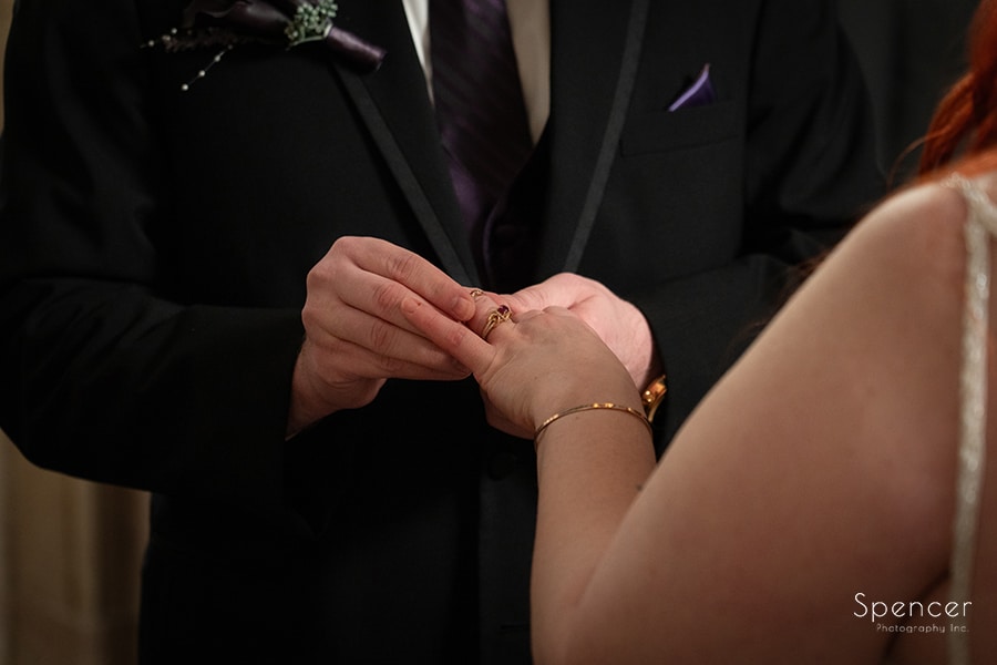 groom putting on wedding ring