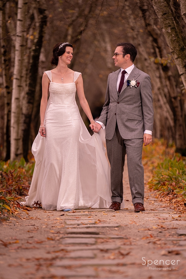 bride and groom walking in birch alley at stan hywet