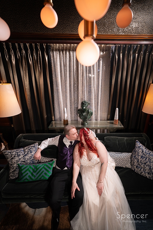 bride and groom kissing on sofa at Marble Room