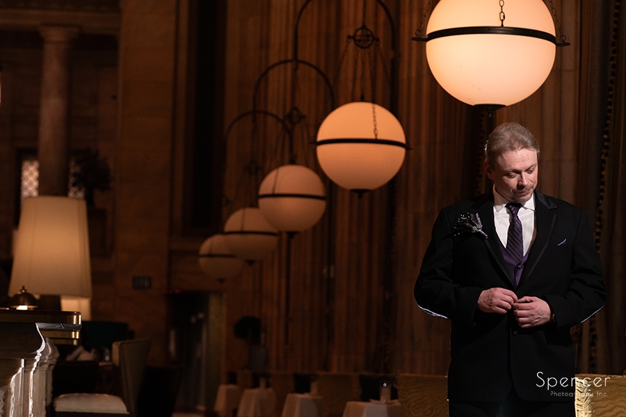 groom buttoning jacket before his wedding at marble room